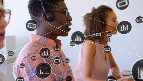 Animation of network of digital icons over diverse man and woman talking on phone headset at office
