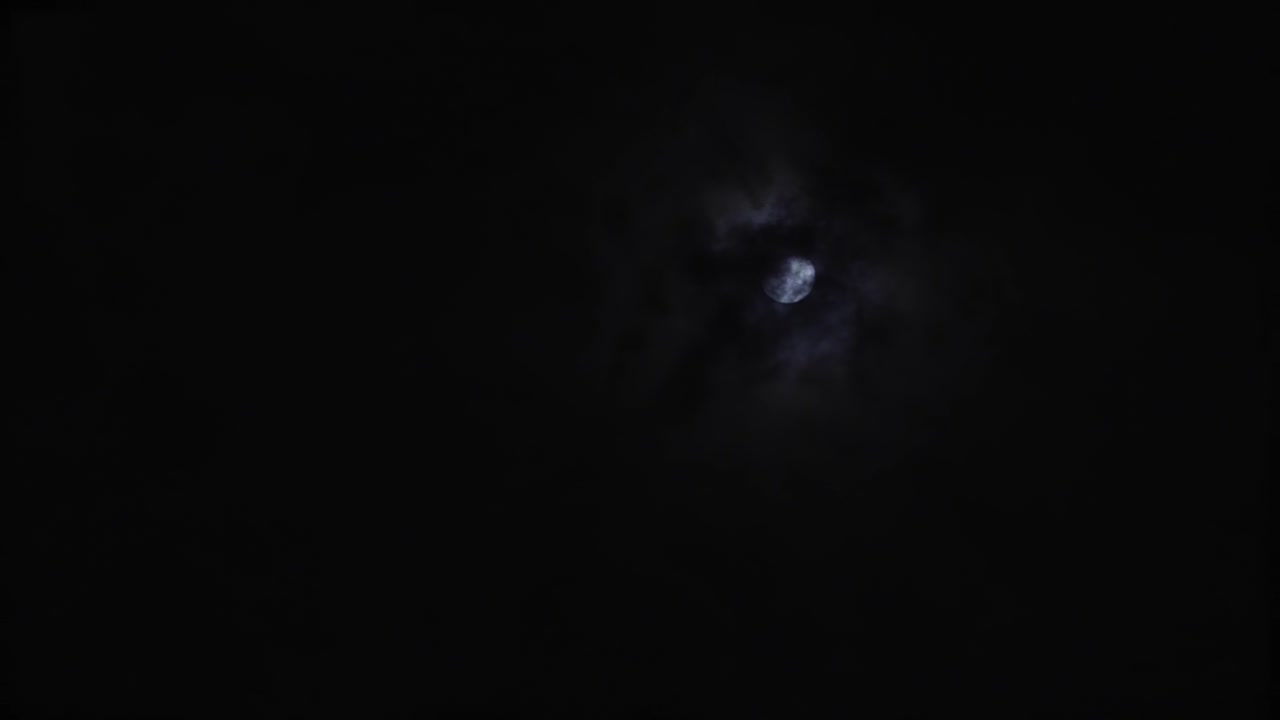una luna llena en el cielo en una noche nublada mientras las nubes se mueven alrededor de la luna
