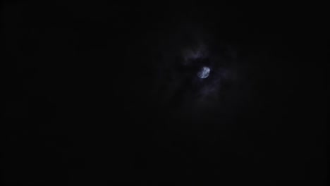 una luna llena en el cielo en una noche nublada mientras las nubes se mueven alrededor de la luna