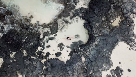 Aerial-footage-of-girl-in-tidepool-on-Oahu,-Hawaii