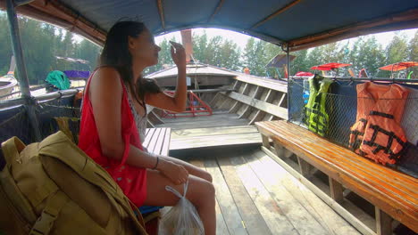 cámara lenta | hermosa niña india en un barco en tailandia poniéndose gafas de sol y esperando para salir al mar