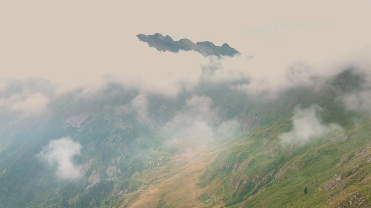 Aerial drone view overlooking a valley, foggy morning, Passo San Marco, Italy