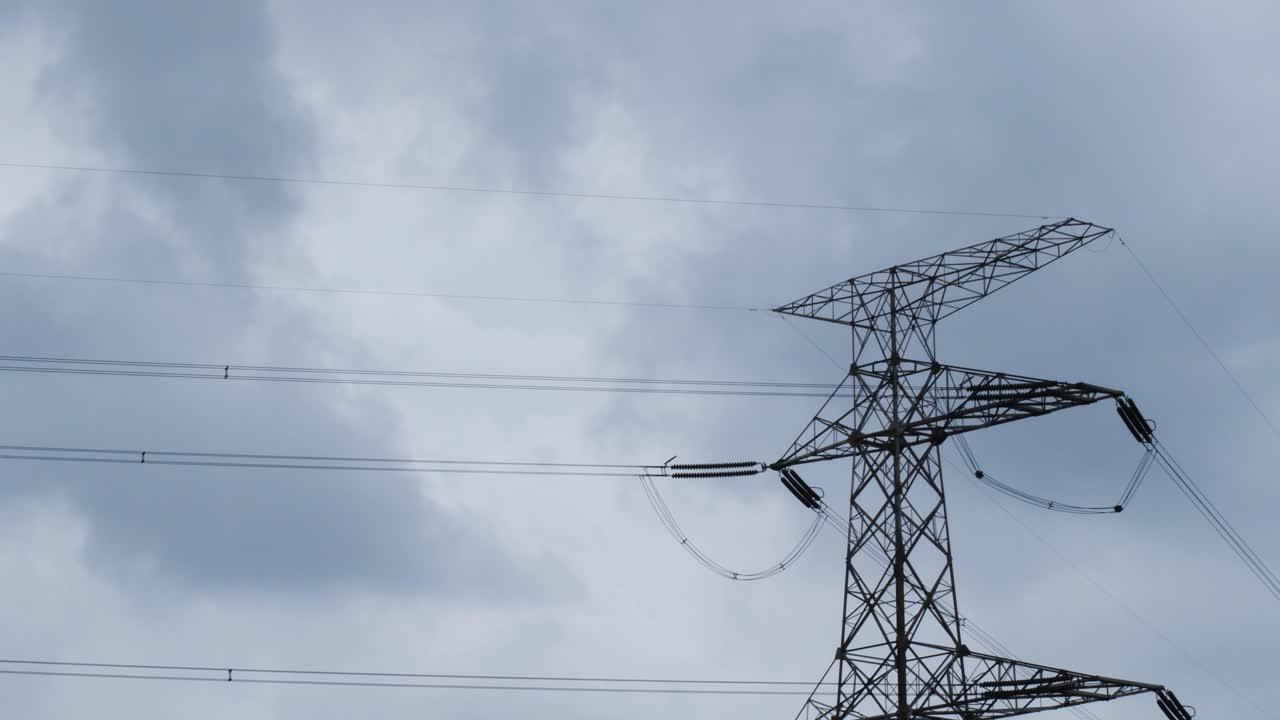 timelapse of a high-voltage power line with a cloudy sky