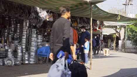 vibrant market atmosphere in islamabad with crowds of people bustling around street vendors and stalls to purchase daily groceries.