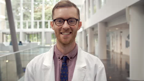 portrait of smiling male doctor in lobby of hospital