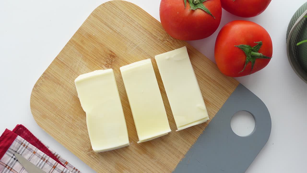 queso y tomate en una tabla de cortar