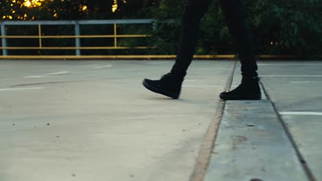 Shot-close-to-Pearson-with-black-boots-and-black-pants-spreading-orange-cones-on-the-road