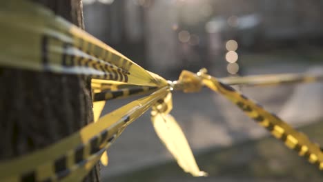 cinta amarilla de precaución en primer plano con un patio de recreo cerrado en el fondo que está borroso