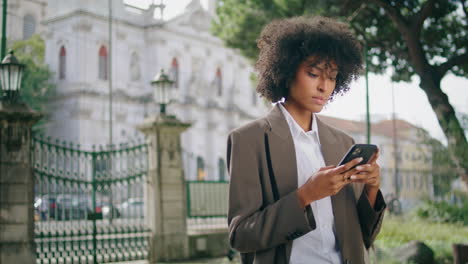 business woman using smartphone in city park closeup. girl holding modern mobile
