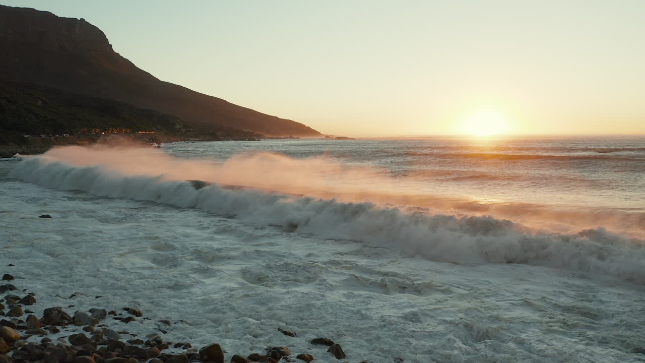 puesta de sol sobre el mar con olas rompientes en ciudad del cabo, sudáfrica