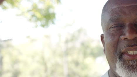 half portrait of happy senior african american man on sunny terrace with copy space, slow motion