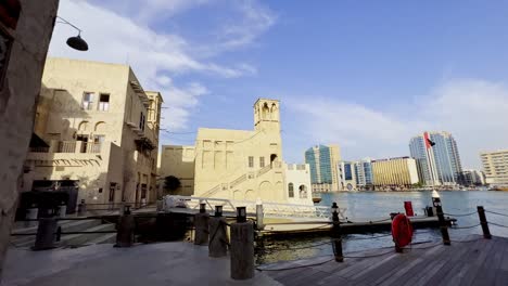 Tiro-De-Plataforma-Rodante-Hacia-La-Rampa-Para-Botes-Y-La-Plataforma-Del-Restaurante-Flotante-Junto-Al-Arroyo-Dubai-En-Al-Seef,-Dubai,-Emiratos-árabes-Unidos