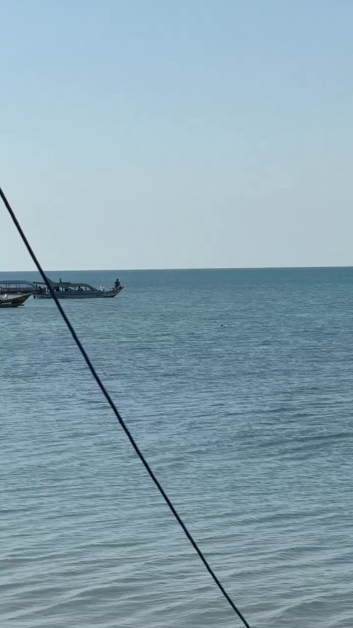 Piccole barche che galleggiano su un mare calmo e blu sotto un cielo sereno