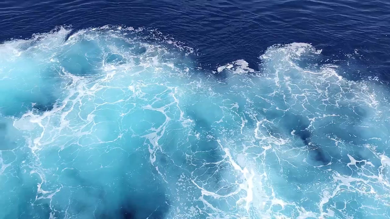 Eau de mer d'un bleu profond avec un sillage écumant