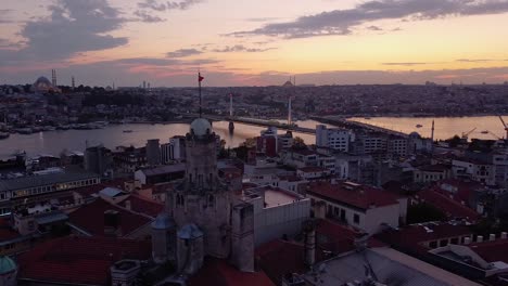 aerial is flying sideways showing galata tower in istanbul after sunset, turkey