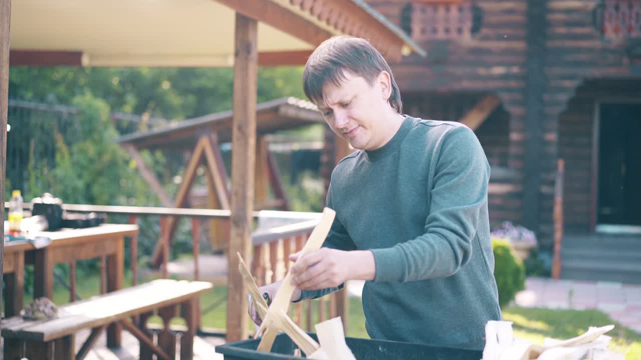 여행하는 젊은 남자는 석탄이 담배를 피우고 있는 바베큐 근처에 서 있습니다.