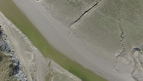 vista aérea de arriba hacia abajo del río a en la bahía de arena en la marea baja, en un día brillante y soleado