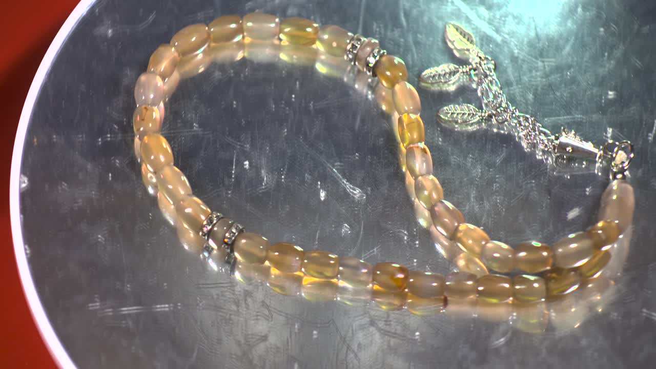 rosario cuentas pinza roja en la parte superior de la mesa giratoria reflectante por encima