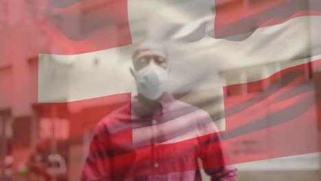 Animation-Der-Flagge-Der-Schweiz,-Die-Während-Der-Covid-19-Pandemie-über-Einem-Mann-Mit-Gesichtsmaske-Weht