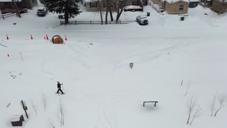 Woman-in-snowshoes-walking-in-snow,-drone-aerial-view,-winter-landscape-of-Ouray-Colorado-USA