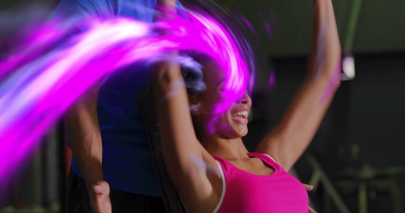 Cliente di fitness che solleva manubri su panca, con un vortice viola che traccia il movimento, e un allenatore che guida