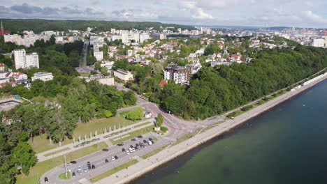 aerial wide shot showing parking area at shoreline of baltic sea and luxury district of gdynia in background