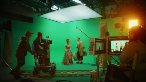 on set: famous female director controls cameraman shooting green screen scene with two actors talented wearing renaissance clothes talking. crew shooting period costume drama movie.