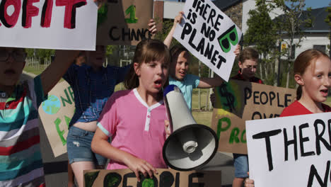 grupo de niños con señales de cambio climático y megáfono en una protesta