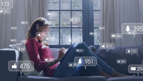 social media notifications animation over woman using tablet on couch