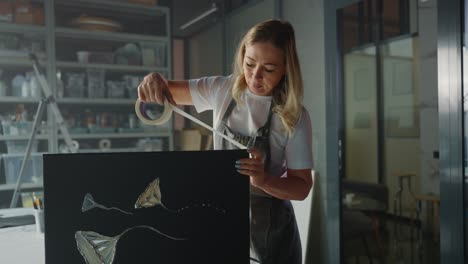 woman artist preparing artwork for framing