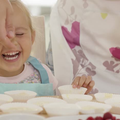 Lächelndes-Mädchen-Mit-Muffin-Haltern-Vor-Ihr