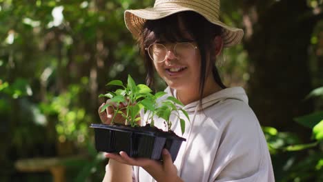 asian girl gardening and smiling on sunny day