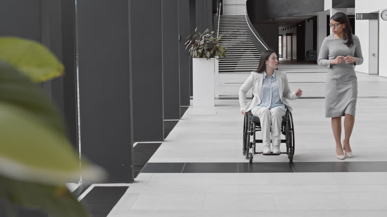 Two Diverse Businesswomen Going along Office and Talking