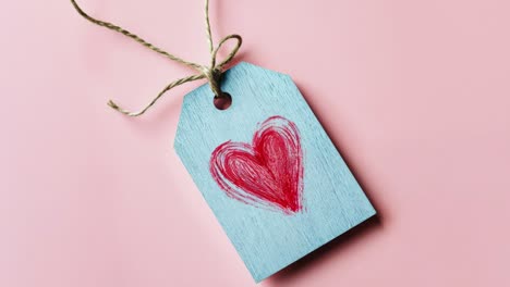 heart-shaped wooden tag on pink background