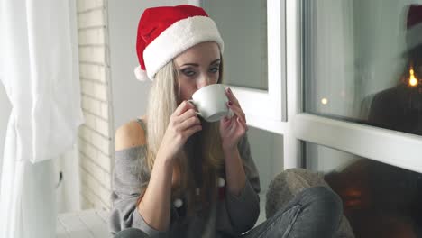 women with cup of tea. young women relaxing with cup of hot drink and warming up on the window sill