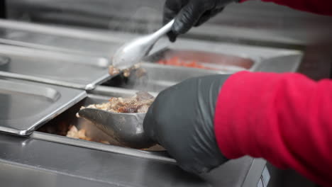 measuring out marinated, chopped chicken and pork for a taco, burrito, mulita, or quesadilla - food truck series