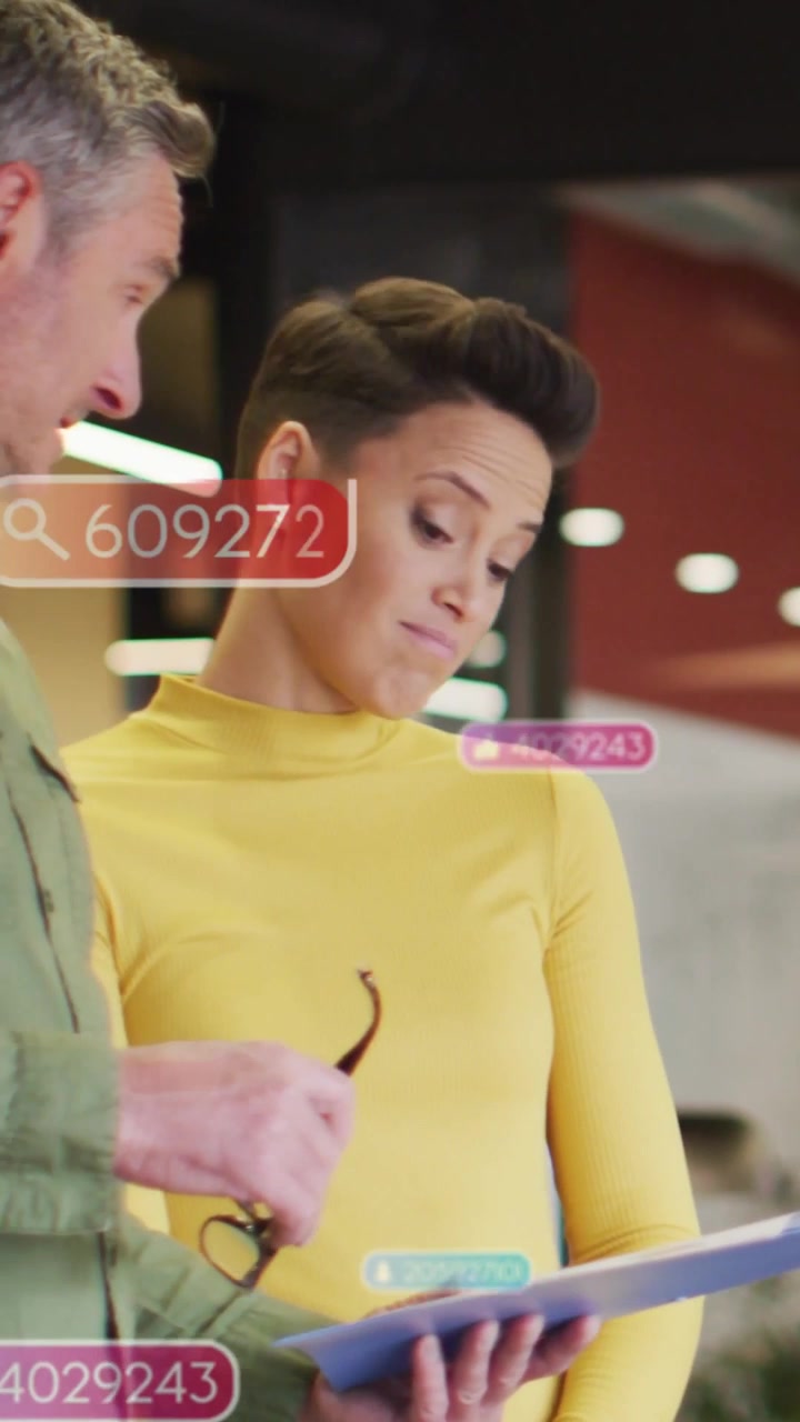 Woman holding tablet man pointing initiating UI badges over tablet while reviewing business report