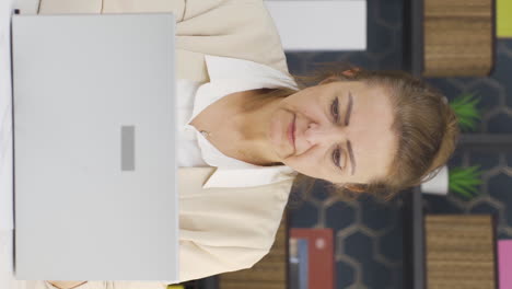 video vertical de una mujer de negocios estresada usando una computadora portátil.