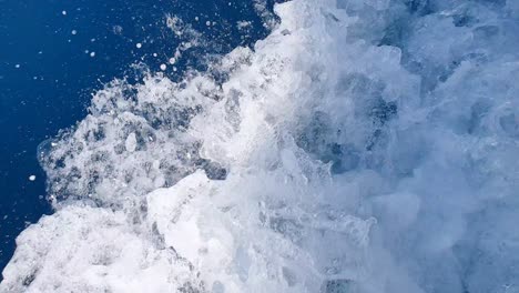 Spray-De-Lavado-Blanco-De-Flujo-Rápido-Y-Despertar-En-El-Agua-Azul-Profunda-Del-Océano-Desde-Una-Lancha-Motora-Que-Se-Mueve-A-Ritmo,-Cerca-Del-Agua-De-Lavado-Blanco