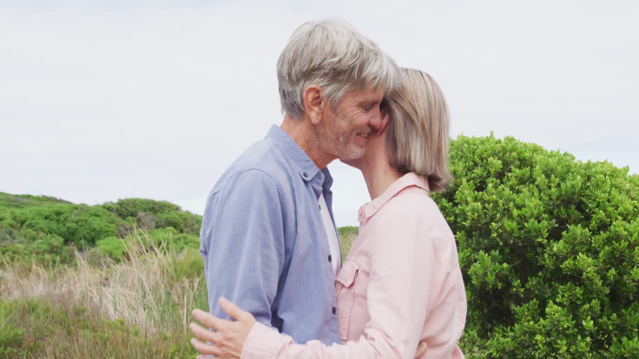 미소 짓는 고위 백인 부부가 야외에서 개와  ⁇ 안고 있다