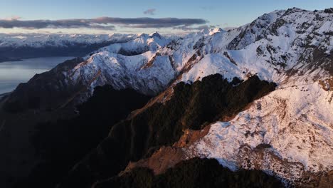 Drone-opening-to-snowy-mountain-ridge,-winter-in-South-Island,-New-Zealand