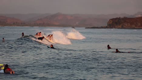 beginner surfers on rolling ocean waves of gerupuk, lombok in indonesia. - tracking shot