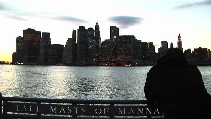 A Tourist Leans Over Boat Railing And Looks Across The River Toward The South Street Seaport Shore Of Manhattan
