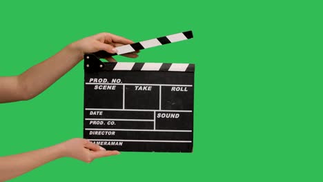 movie clapper board clapped. close up female hand hold empty black and white stripe film making movie slate isolated on green screen chroma key background studio. slow motion