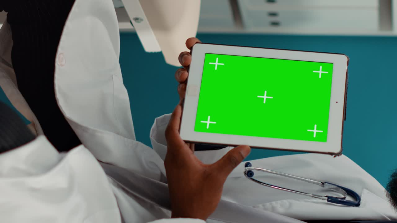 General practitioner holding digital tablet with greenscreen