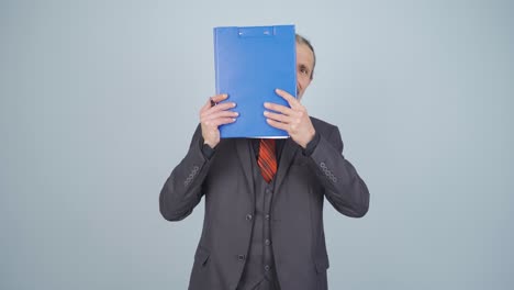 businessman looking from behind files.