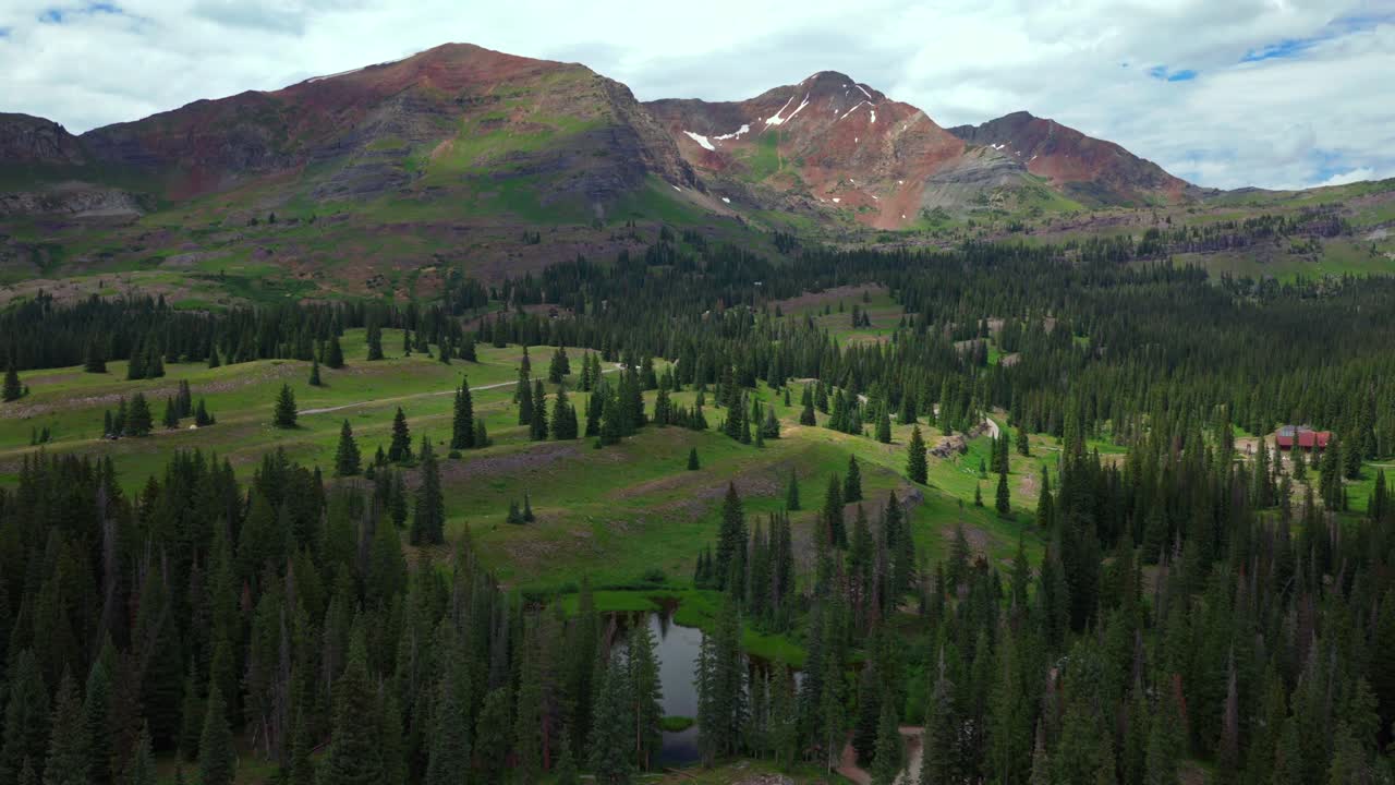 Campeggio Kebler Pass Lake Irwin Trail primavera estate aerea drone Crested Butte Colorado Gunnison National Forest Robinson Basin Ruby Peak tenda arancione mattina cielo blu nuvole panoramica in avanti verso l'alto