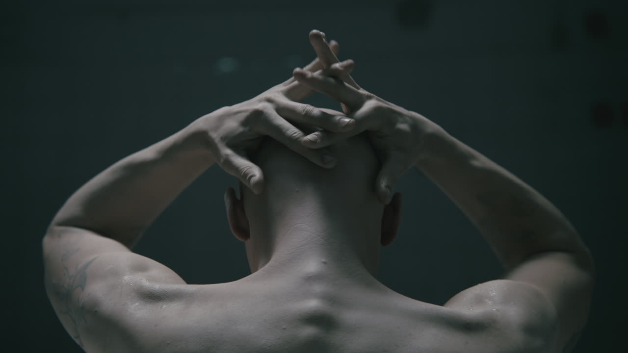 Pale bald skinny man takes a bath in the creepy old bathroom at night