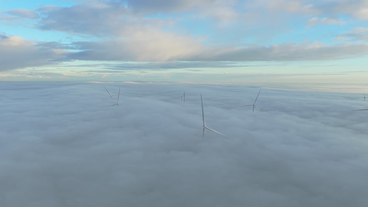 Nizozemské pobřežní turbíny se vynořují z ranní mlhy a generují čistou větrnou energii.