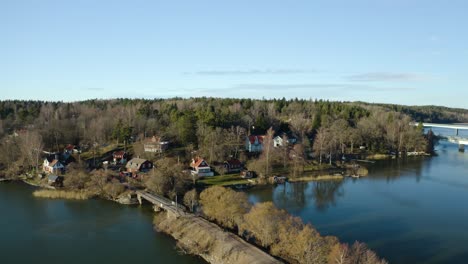 Peaceful-charming-Swedish-settlement-Ekolsund,-Sweden-in-harmony-with-nature-on-the-banks-of-the-river-with-highway-bridges-in-the-background